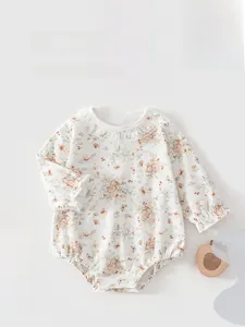 Détail d'une barboteuse bébé avec col en dentelle et motifs lapins sur coton doux et souple