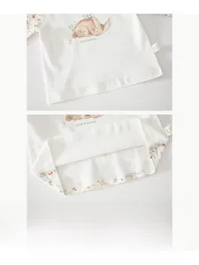 Close-up of white baby cotton top with rabbit print and fine double stitching details