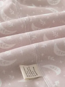 Pink cotton baby pajama set featuring seamless stitching and celestial moon print pattern