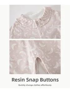 Detail of baby romper featuring ruffled collar and white resin snap buttons on cotton fabric