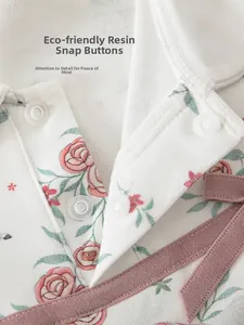 Detail of floral baby top with eco-friendly resin snaps and a decorative pink bow