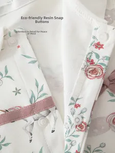 Detail of baby cotton romper featuring resin snaps and floral unicorn prints