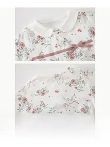 Detail of baby bodysuit collar with soft pink bow and unicorn floral pattern print