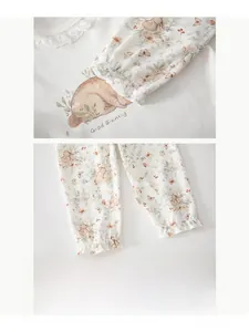 Close-up of cotton baby pajamas set with lace trim details and rabbit floral print