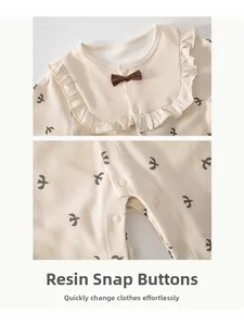 Detail of baby romper with resin snap buttons for easy dressing and ruffled collar