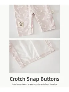 Detail of snap button crotch on baby pink cotton romper with moon and star patterns