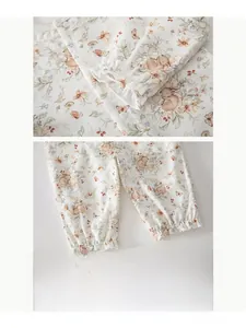 Detail of floral baby bodysuit featuring lace trim, elastic cuffs, and cute bunny prints