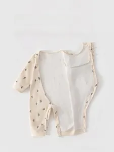Detail of baby cotton romper with bird print and side-snaps for easy dressing
