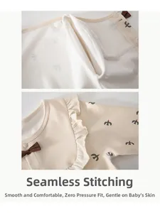 Detailed macro view of soft cotton baby romper featuring a sweet bow and ruffled collar