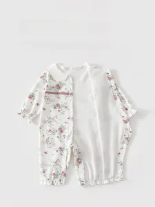 Close-up of baby floral romper with snap buttons, ruffle edges and soft cotton texture