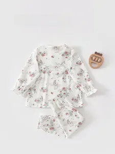 Detail of baby cotton pajama set featuring pink unicorn prints and ruffled cuffs