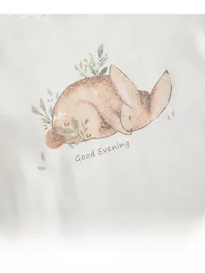Detail of soft cotton baby sleepwear set with Good Evening bunny print and texture