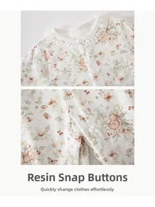 Detail of the baby bodysuit showing white lace collar and snap button closure