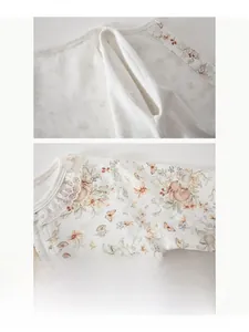 Detail of floral baby romper with delicate lace collar and soft flat-seam construction