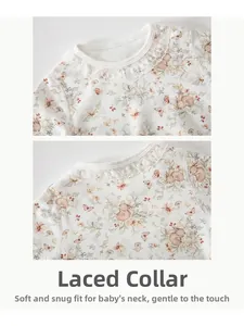 Détail de l'encolure d'une barboteuse pour bébé avec dentelle et motif floral délicat