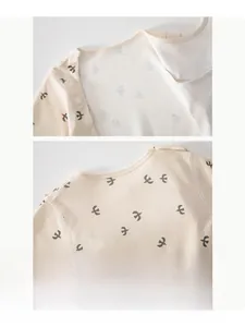 Close-up of comfortable cotton baby bodysuit collar with delicate bird print patterns
