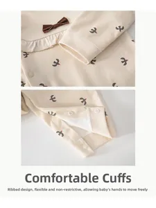 Detail of baby romper with bird print, ribbed cuffs, and snap buttons for easy diapering