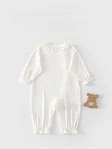 Detailed back view of white long-sleeved baby romper with ribbed fabric and ruffle edges