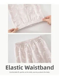 Detail of high-elastic waist on pink cotton baby leggings with moon and star patterns