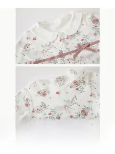 Close-up of baby girl top with Peter Pan collar and pink unicorn flower pattern