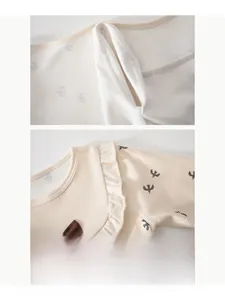 Detail of baby romper featuring bird print, ruffled collar with bow, and smooth flat seams