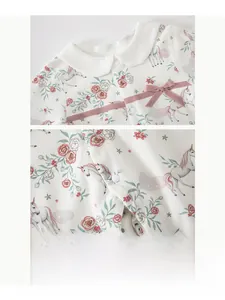 Close-up of baby girl cotton romper with floral unicorn print and pink bow detail