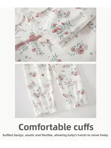 Detailed close-up of elastic ruffled cuffs on cotton baby bodysuit with floral patterns