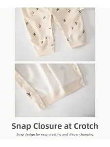 Detail view of cotton baby bodysuit crotch featuring snap fasteners and bird print