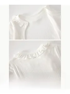 Close-up of baby romper's breathable ribbed fabric with delicate ruffled collar and snap buttons