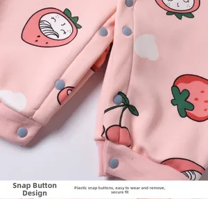 Detail of snap buttons and strawberry print on soft baby romper fabric in close-up