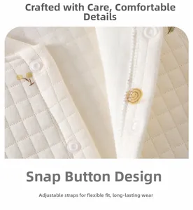 Macro detail of baby romper snap closure with yellow snail patterns on quilted fabric