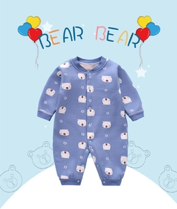 Detail of baby onesie showing blue fabric with white bear pattern and snap button closure