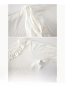 Detail of soft ribbed cotton baby bodysuit featuring ruffle collar and flat seam sewing