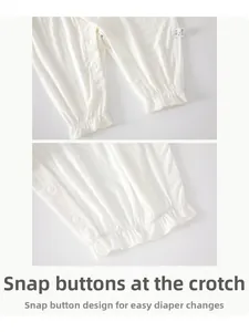Close-up of bottom snap buttons and ribbed knit fabric texture on white baby romper