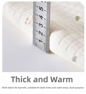 Close-up of thick quilted fabric for baby rompers featuring cute bear prints and green leaves