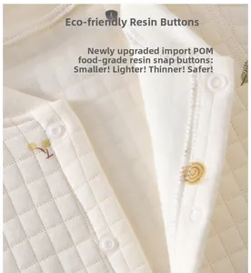 Detail view of baby romper featuring quilted fabric and eco-friendly resin buttons