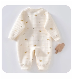 Detailed macro view of quilted diamond texture and snail patterns on baby romper