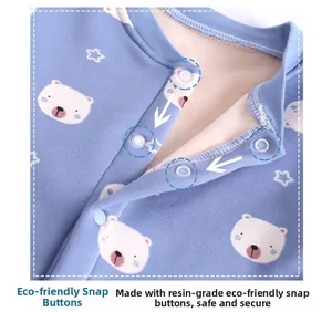 Close-up of eco-friendly resin snap buttons on a light blue baby romper with bear print