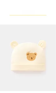 Close-up of baby cotton hat in yellow featuring 3D ears and cartoon bear design