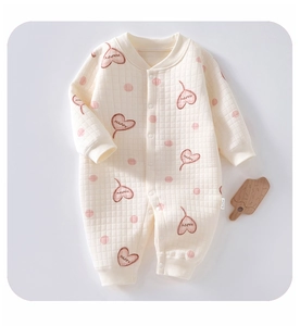 Detail of baby quilted romper featuring pink polka dots and heart print with ribbed cuffs