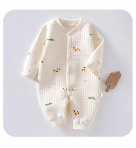 Detail view of quilted baby romper with airplane print and snap button closure