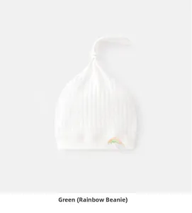 Detail of soft cotton baby knot hat featuring an embroidered rainbow and cloud patch