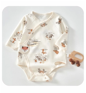 Detail of baby cotton bodysuit with fox and forest prints and side buttons closure