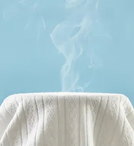 Macro detail of breathable white cotton knitted baby fabric showing steam for airflow