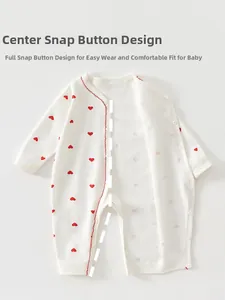 Détail d'un pyjama pour nouveau-né avec motifs cœurs et fermeture à boutons-pression