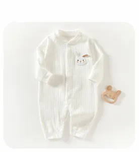 Détail de la barboteuse bébé en maille côtelée blanche avec écusson lapin brodé