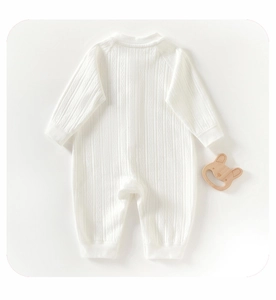 Détail d'un body blanc en coton pour bébé avec une texture en maille côtelée douce