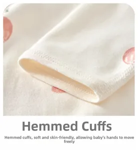Macro shot of soft cotton baby bodysuit cuffs with cherry print and fine edge binding