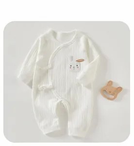 Detail of white cotton newborn romper featuring a cute rabbit embroidery and side ties
