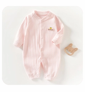 Détail d'un barboteuse rose en coton pour bébé avec texture côtelée et broderie douce